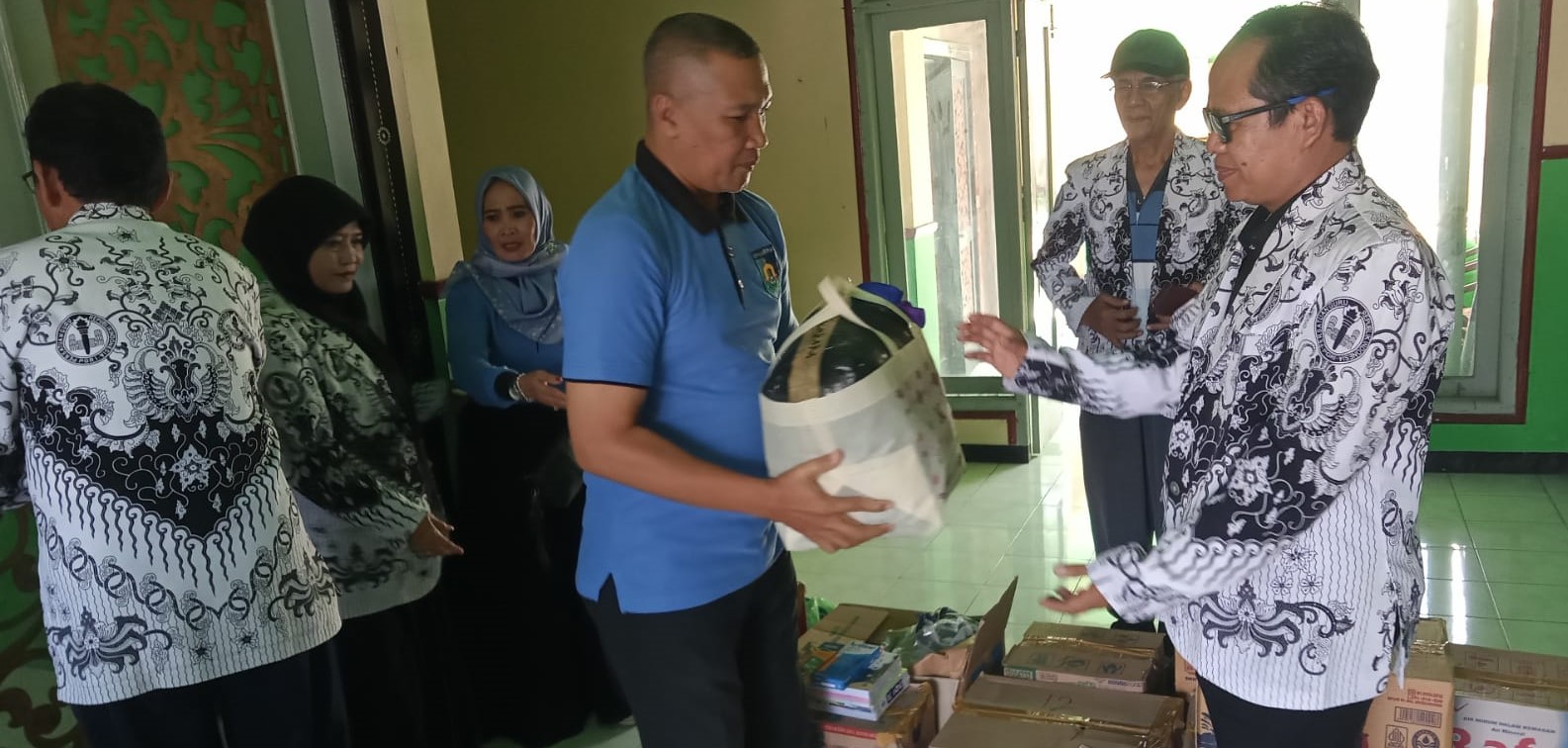 Ketua PGRI NTB Yusuf (kanan) menerima bantuan secara simbolis untuk siswa dan guru terdampak banjir Mataram di Posko PGRI NTB, Sabtu lalu (26/7).