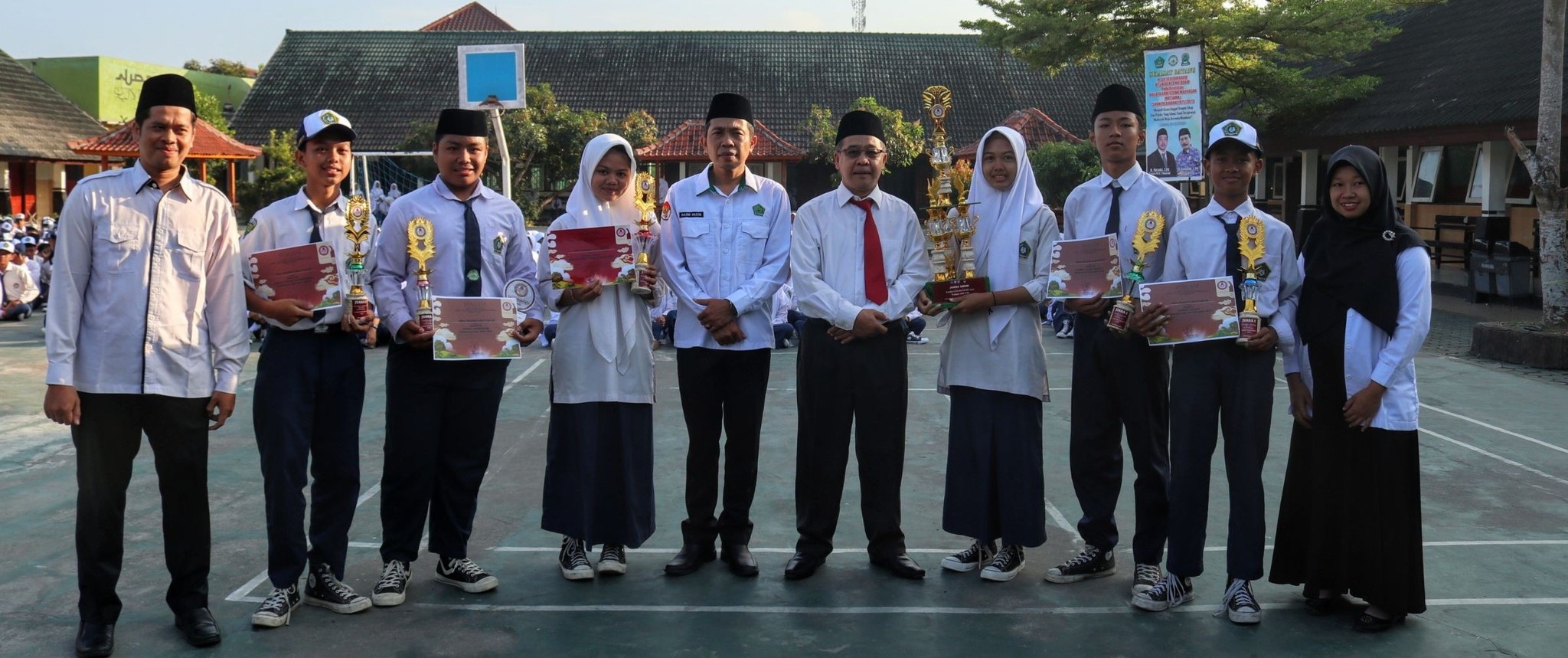 Kepala MTsN 3 Mataram Marzuki (lima dari kanan) foto bersama siswa berprestasi dalam berbagai kejuaraan di lapangan madrasah setempat, Senin (28/7).