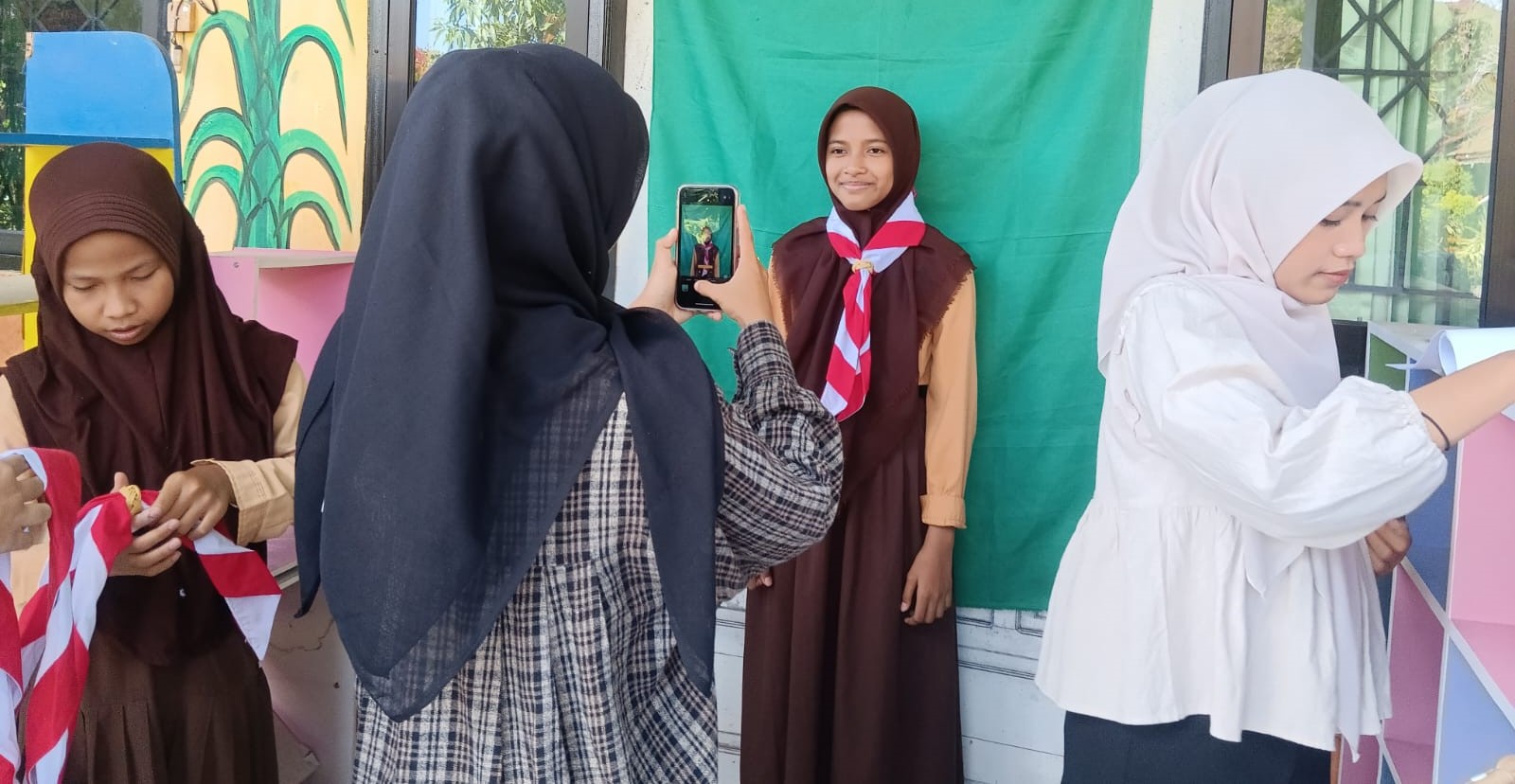 Murid SDN 33 Mataram melakukan pemotretan pembuatan KTA Pramuka digital di sekolah setempat, Jumat (1/8).