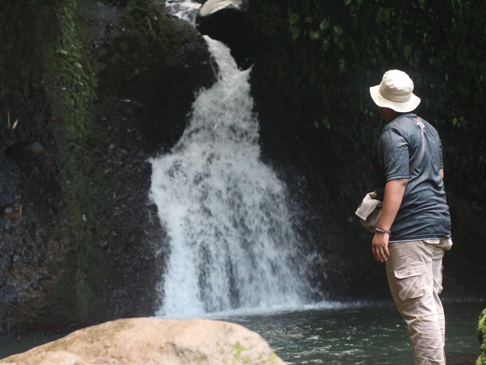 Seorang Pengunjung Sedang Menikmati Keindahan Air Terjun Durian Indah