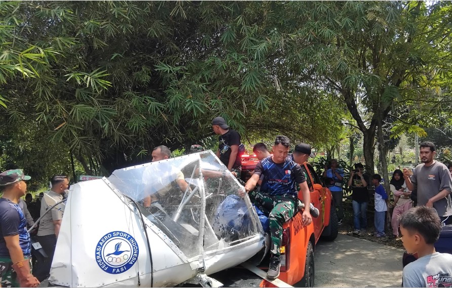 EVAKUASI: Petugas memeriksa bagian pesawat dan mengevakuasi korban pesawat latih yang jatuh di kawasan TPU Astana, Desa Benteng, Ciampea, Kabupaten Bogor, Minggu (3/8).