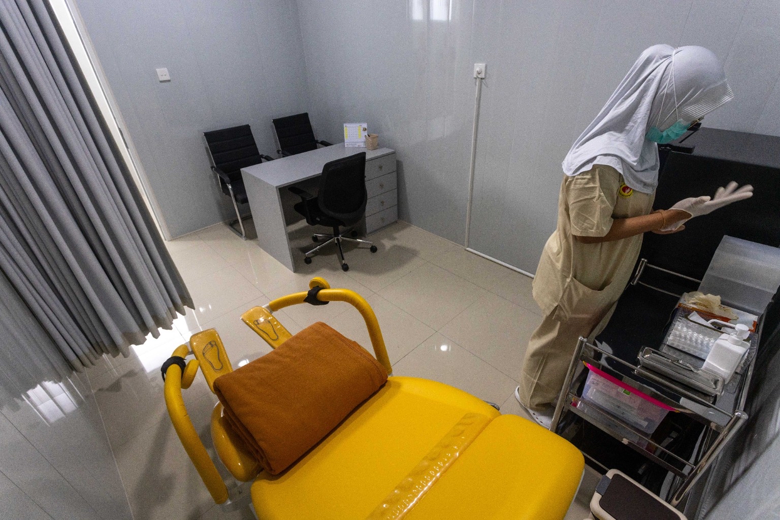 RUANG PEMERIKSAAN AWAL: Ruangan tempat pasien wanita menjalani evaluasi medis dan USG transvaginal sebelum memulai tahapan program bayi tabung. Kursi khusus berwarna kuning terang dilengkapi sandaran.
