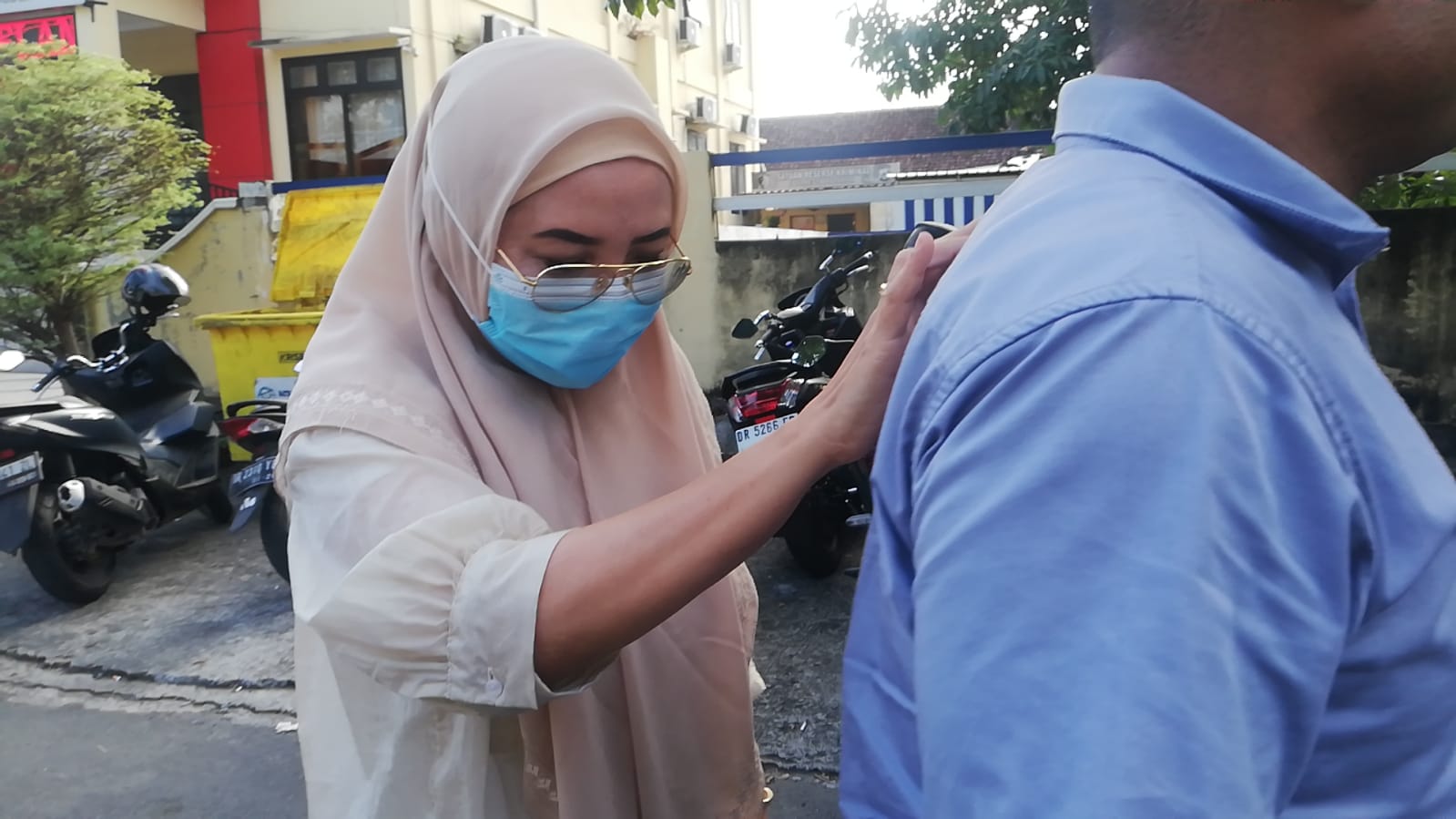 DITAHAN: Tersangka korupsi pengadaan masker Covid-19 Rabiatul Adawiyah memegang pundak penyidik saat hendak dibawa ke sel tahanan untuk ditahan, Sabtu (2/8).