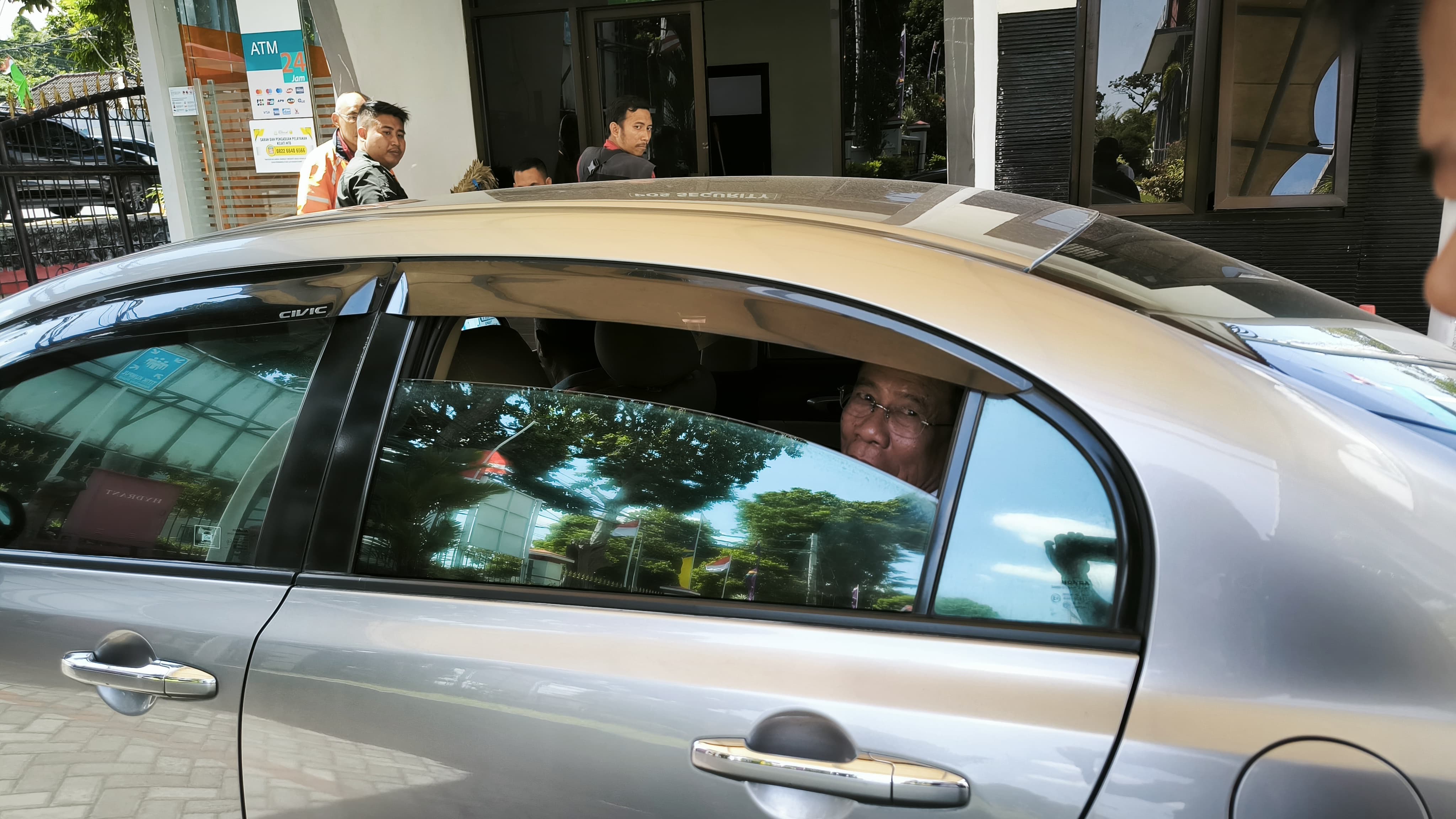 BERIKAN KETERANGAN: Mantan Kadis PUPR NTB membuka kaca mobilnya saat ditanyakan awak media usai pemeriksaan di kantor Kejati NTB, Senin (4/8).