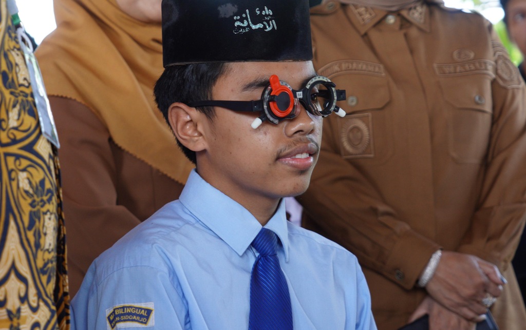 Seorang santri sedang melakukan pemeriksaan kesehatan mata di pondok pesantrennya tempat menimba ilmu. Ini merupakan bagian dari program cek kesehatan gratis masuk sekolah.