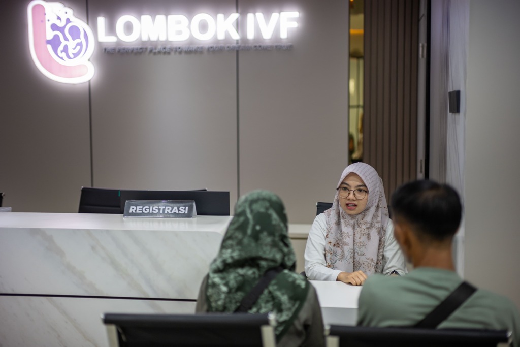 MENENANGKAN: Seorang petugas administrasi IVF melayani pasangan pasien di meja registrasi, ruang pertama yang menyambut harapan dan awal dari perjalanan menuju kehamilan melalui program bayi tabung.