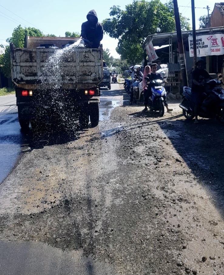 Petugas Balai Pemeliharaan Jalan Pulau Lombok menyiram ruas jalan Praya-Keruak agar tidak berdebu. Persisnya di Jalan Raya Desa Ganti, Kecamatan Praya Timur, Loteng.