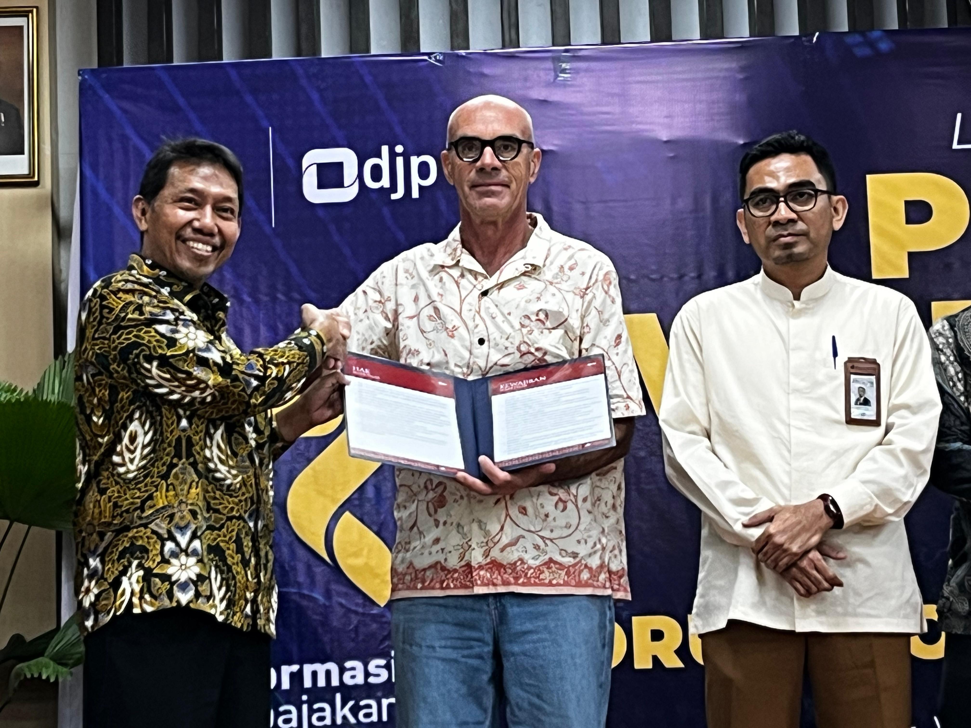 Kepala Kanwil DJP Nusra Samon Jaya (kiri) menyerahkan piagam wajib pajak pada salah satu wajib pajak teladan, Selasa (5/8)