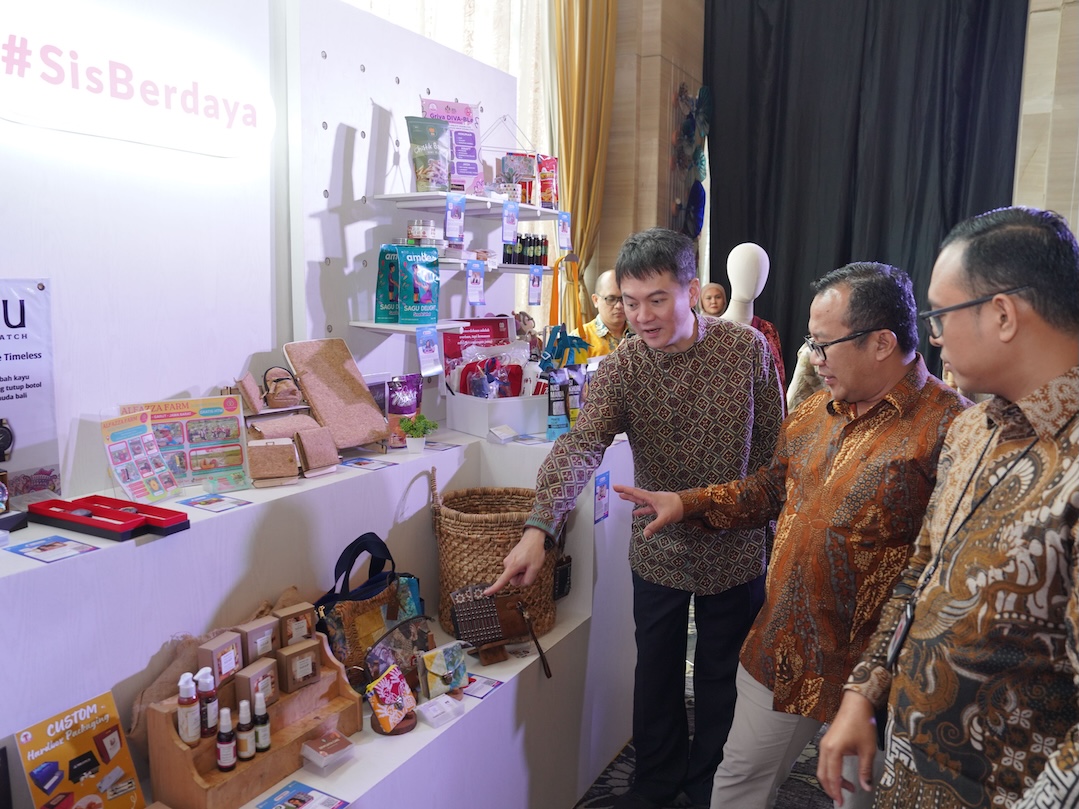 Perwakilan OJK, DANA Indonesia, dan Ant Internasional Indonesia saat melihat produk UMKM perempuan yang dipamerkan selama kegiatan.