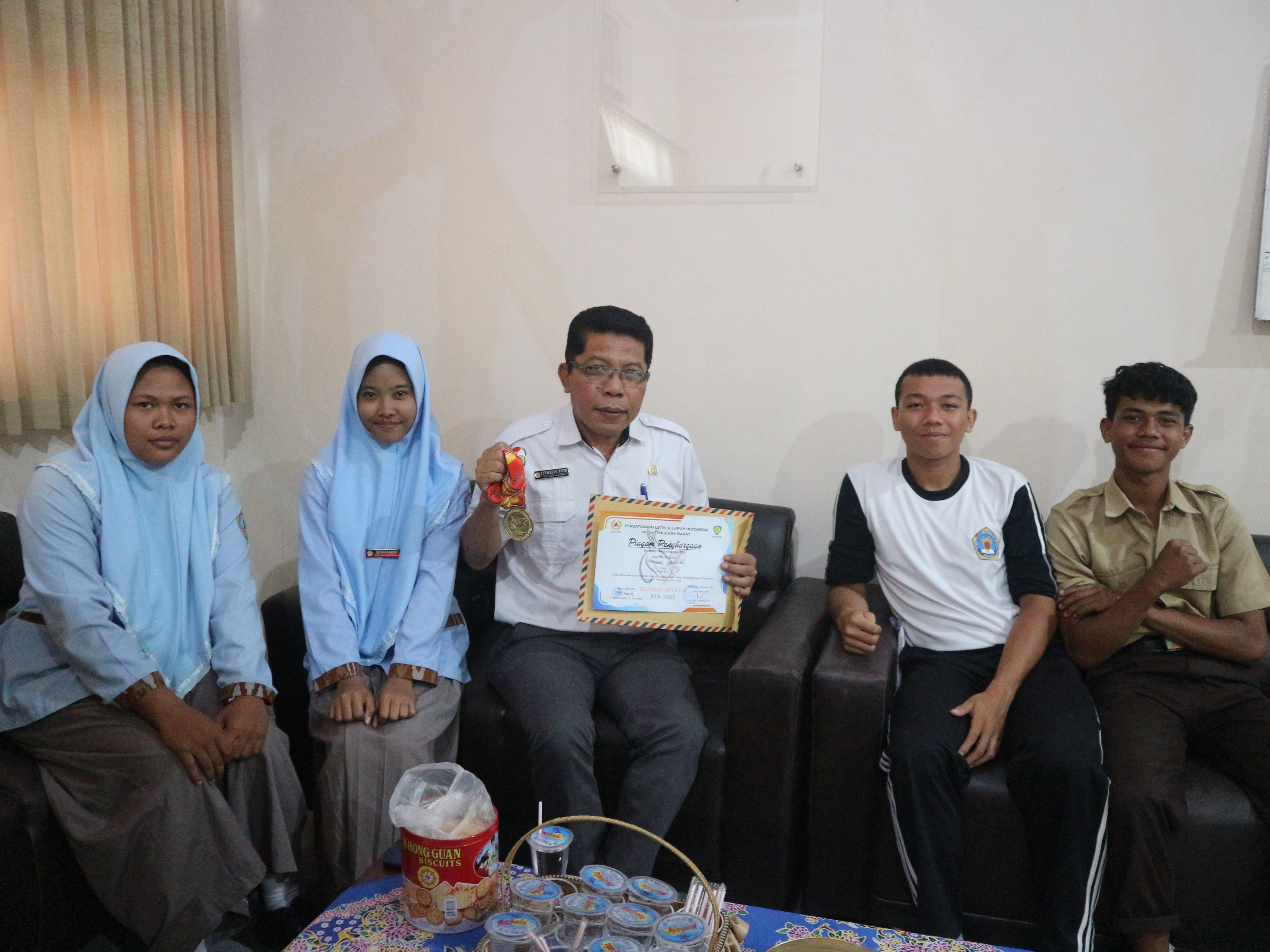 Kepala SMAN 3 Selong Syawalul Fitri saat memperlihatkan slah satu piagam dan medali emas yang di dapatkan oleh Empat orang siswa SMAN 3 Selong ada Kerjurda 2025, Rabu (6/8).