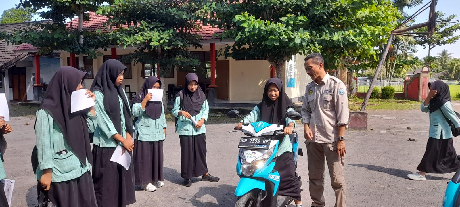 Siswi SMKN 1 Jonggat mencoba bebek listrik hasil konversi sepeda motor BBM menjadi motor listrik di sekolah setempat.
