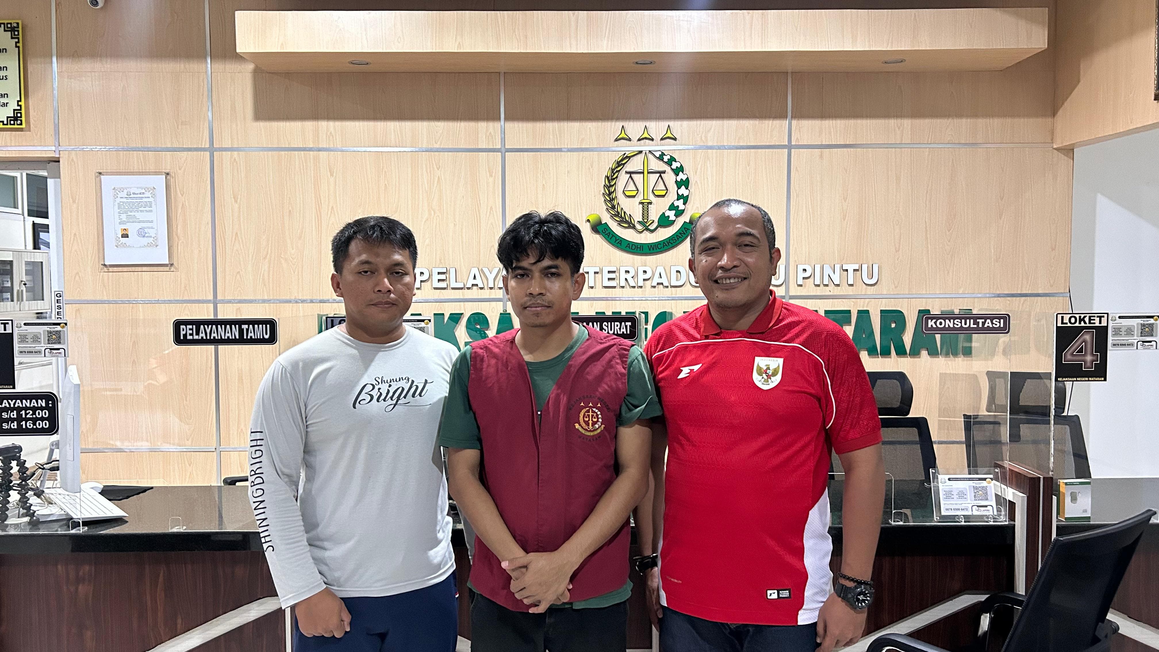 Tersangka Asraruddin (tengah) datang menyerahkan diri di Kejari Mataram, Sabtu (9/8).