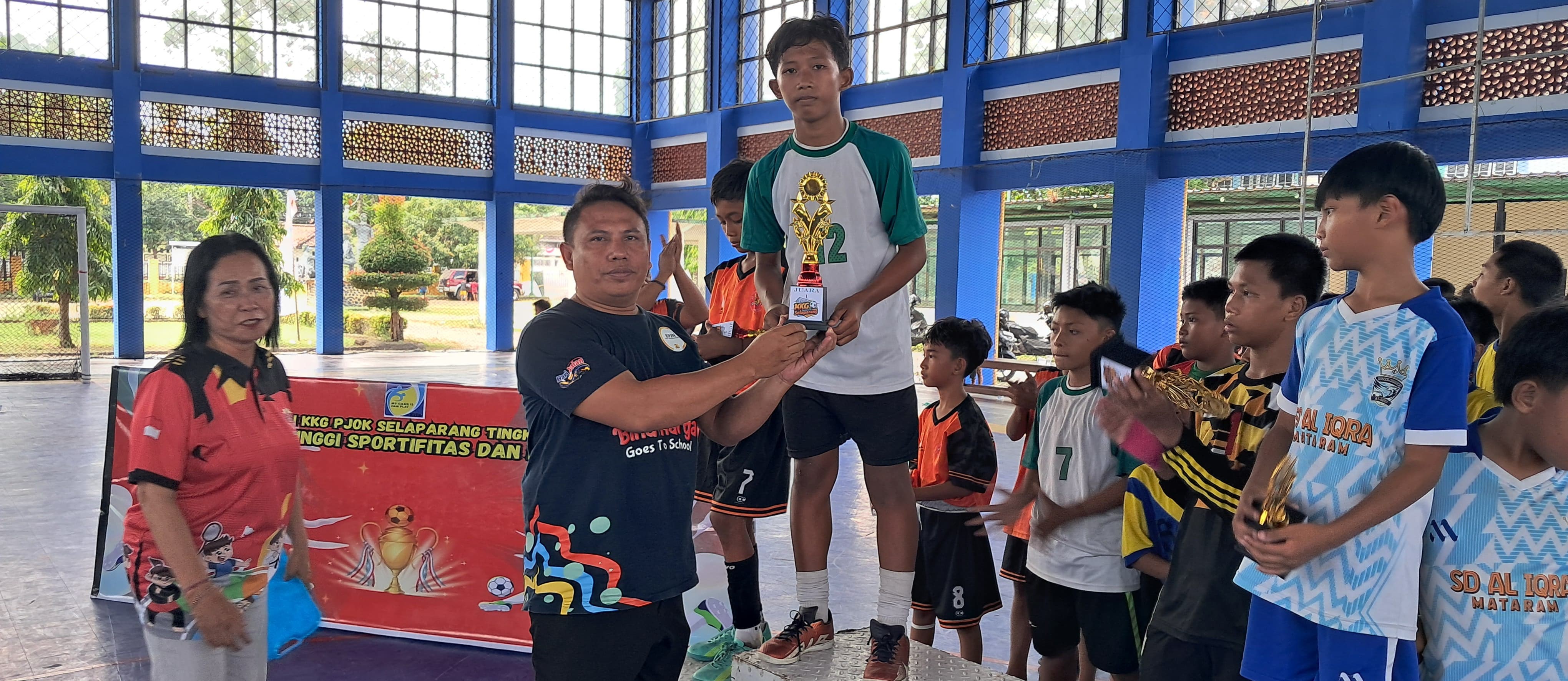 Tim Futsal SDN 33 Mataram menerima piala juara I dalam Kejuaraan Futsal KKG PJOK Kecamatan Selaparang di Gelanggang Pemuda Mataram, Minggu (10/8).