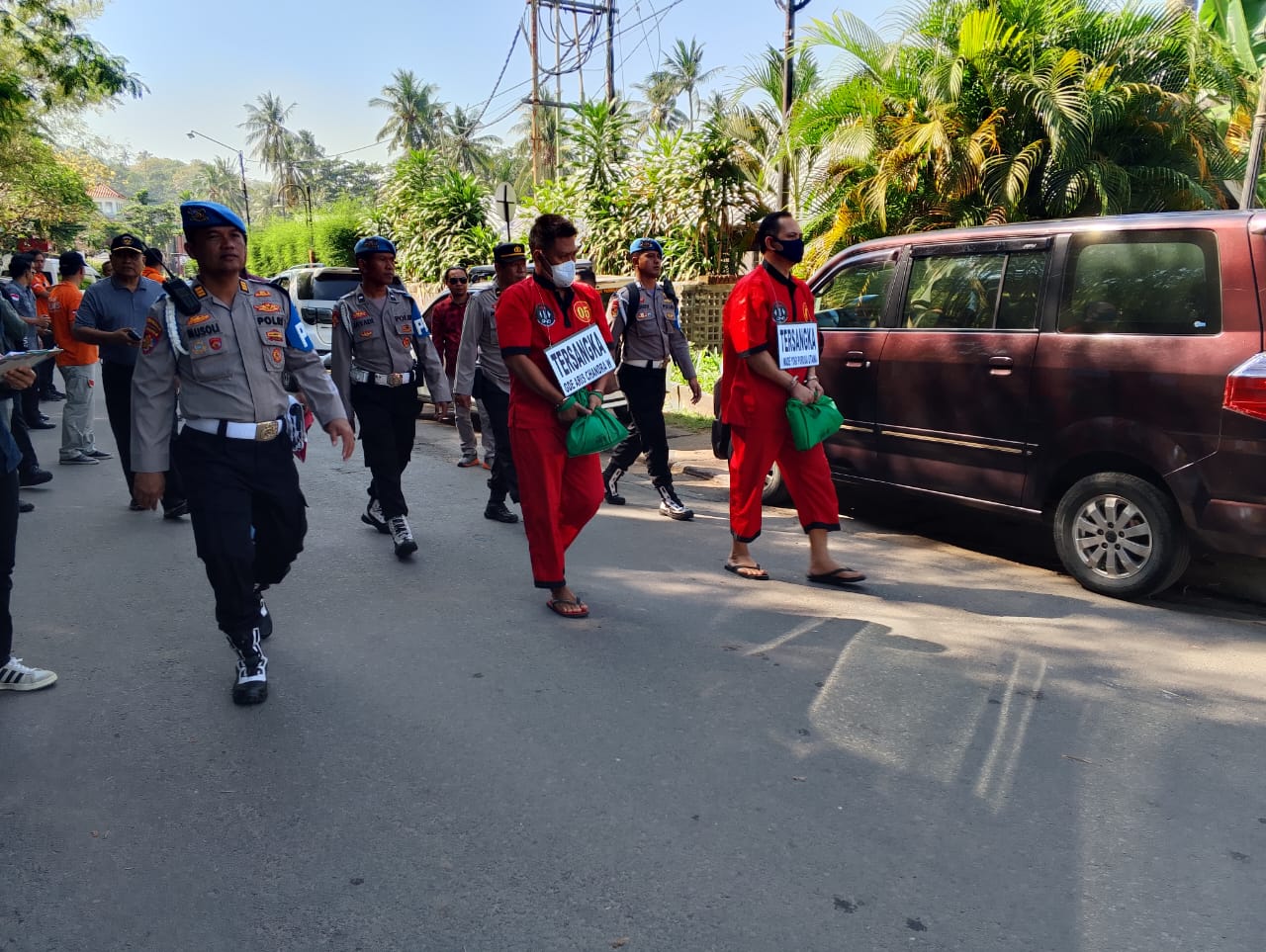 REKONSTRUKSI: Dua tersangka kasus kematian Brigadir Nurhadi Kompol Yogi dan Ipda Haris berjalan saat melakukan rekonstruksi di Senggigi, Lombok Barat (Lobar), Senin (11/8).