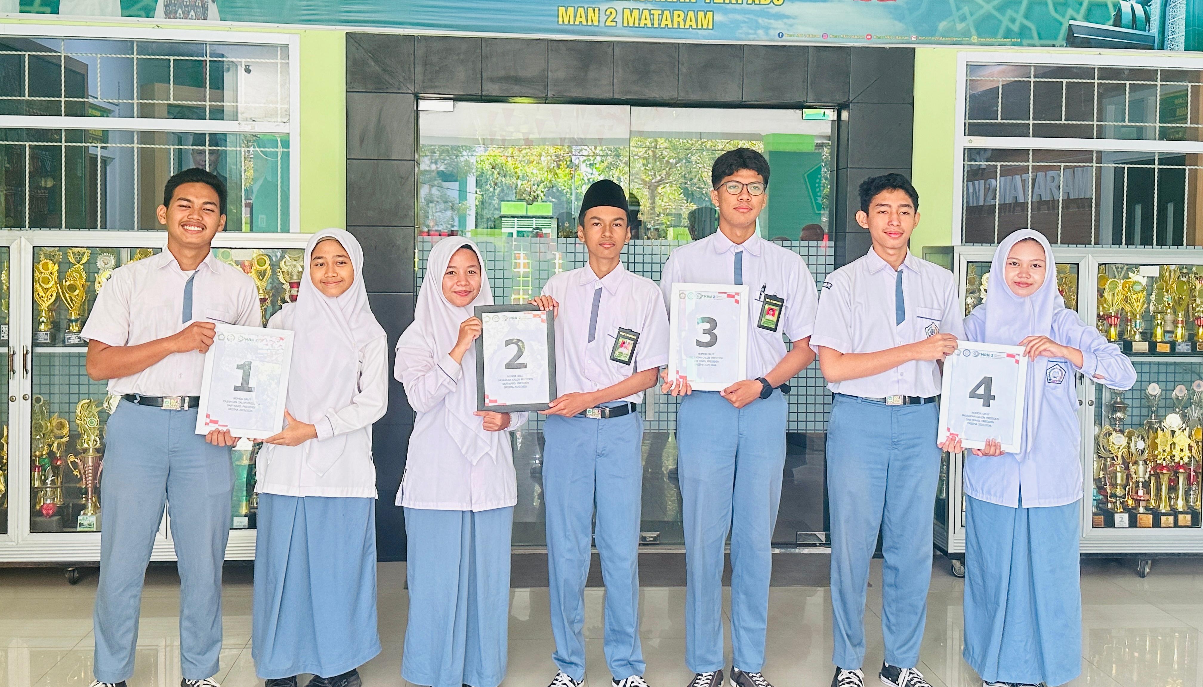 Empat Paslon Capres-Cawapres Orsima MAN 2 Mataram menunjukkan nomor urut di madrasah setempat, Senin (11/8).