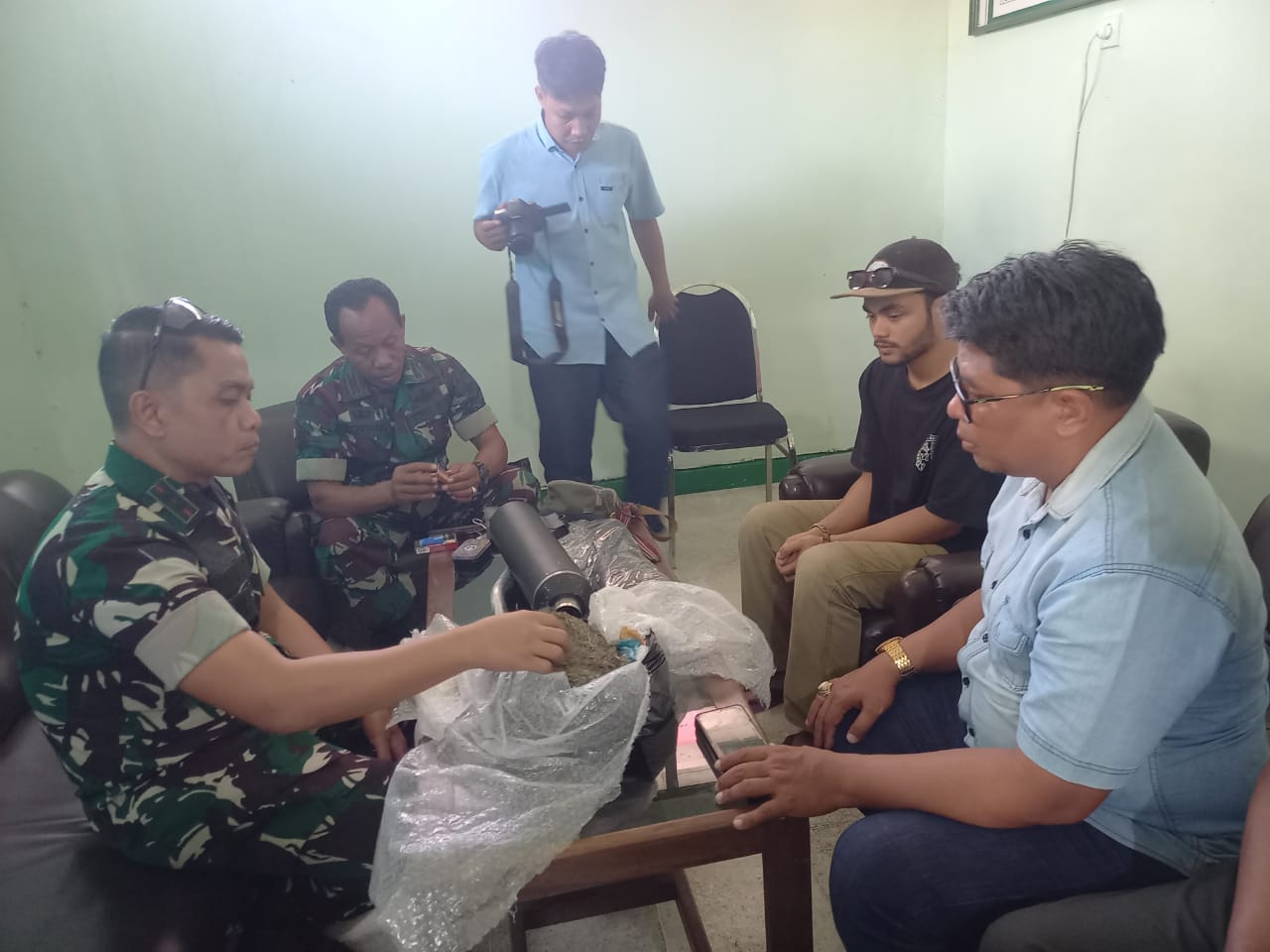 Komandan Kodim 1620/Loteng Letkol Arm Karimmuddin Rangkuti (kiri) mengamankan oknum mahasiswa inisial MAR saat menjemput paket berisi ganja seberat 488 gram di kantor ekspedisi setempat, Selasa (12/8)
