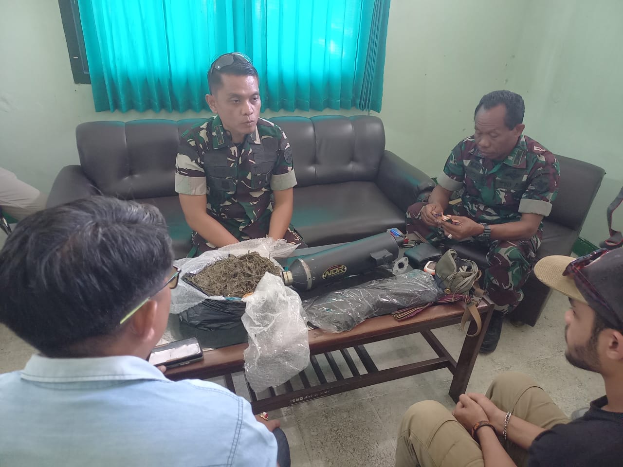 Komandan Kodim 1620/Loteng Letkol Arm Karimmuddin Rangkuti (tengah) mengamankan oknum mahasiswa inisial MAR saat menjemput paket berisi ganja seberat 488 gram di kantor ekspedisi, Selasa (12/8)