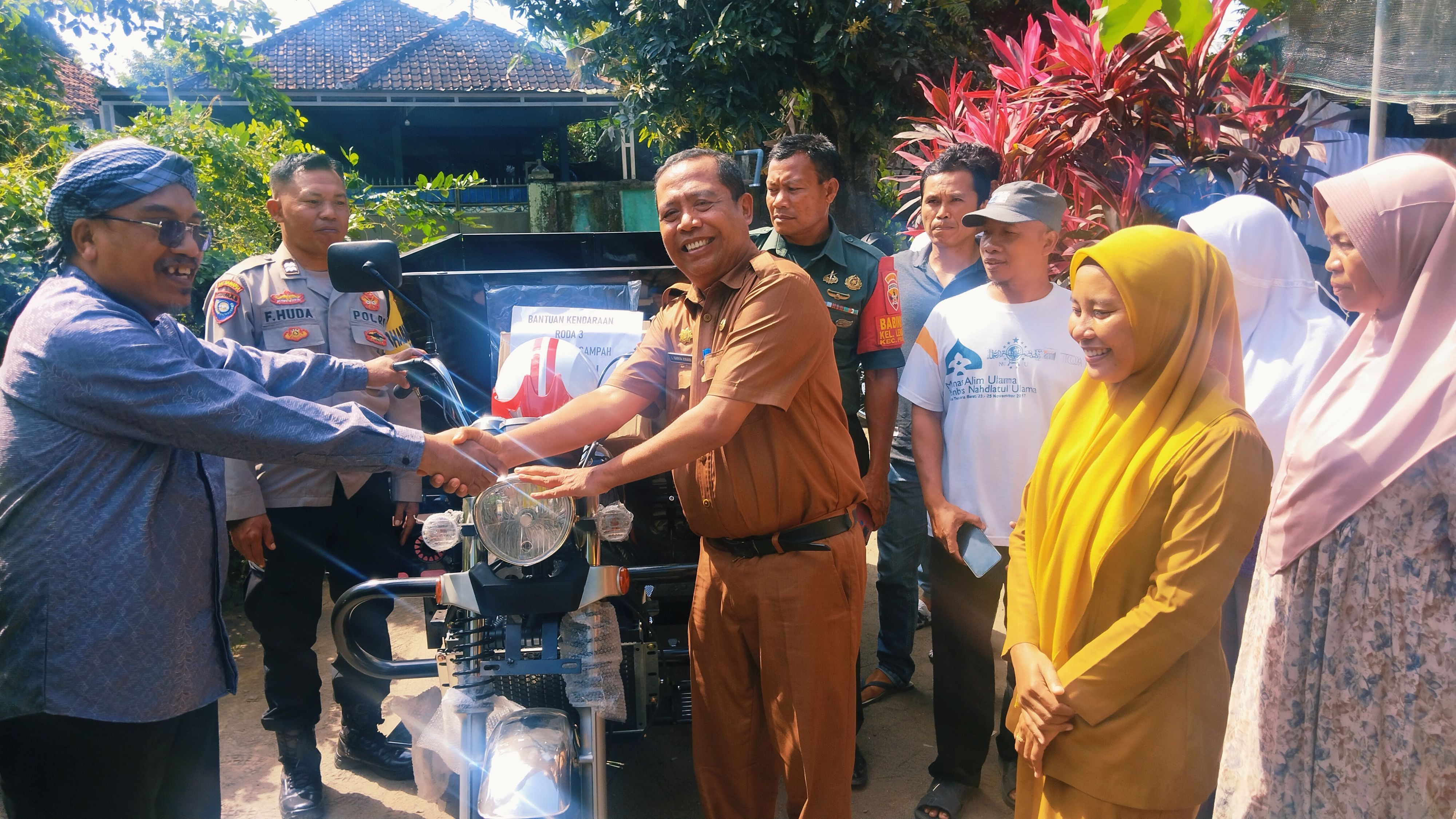 Anggota DPRD Loteng Ahmad Supli menyerahkan bantuan kendaraan pengangkut sampah dari dana pokir dewan