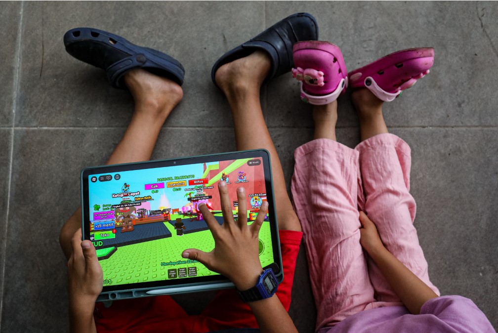 TIDAK COCOK UNTUK ANAK: Dua anak sedang bermain game Roblox di Depok, Jawa Barat, kemarin (12/8). Pemerintah melalui Mendikdasmen Abdul Mu