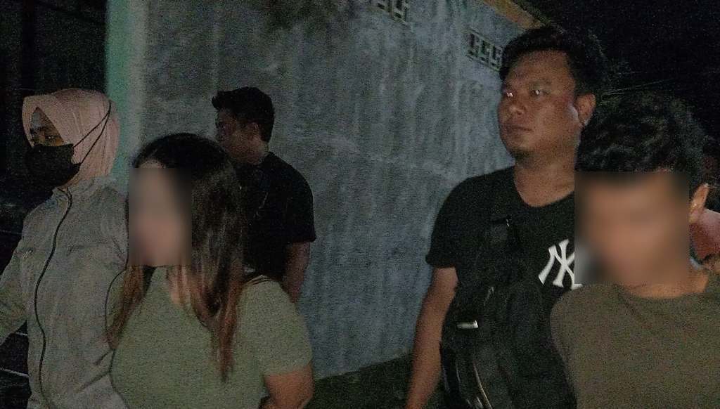 DITANGKAP: Pasutri berinisial SR dan R dikawal polisi usai ditangkap di Jalan Energi, Ampenan, Selasa dinihari (12/8).&nbsp;