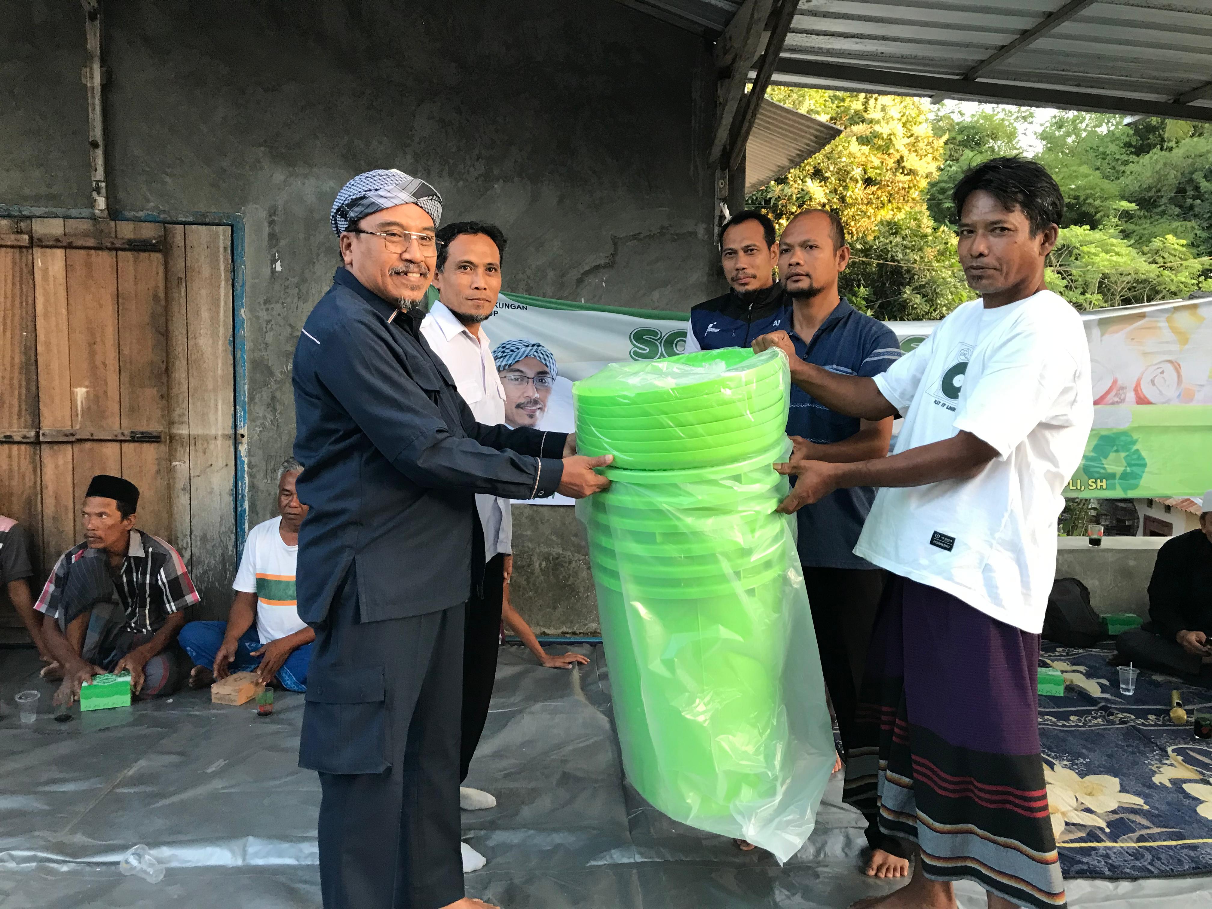 Anggota DPRD Loteng Ahmad Supli (kiri) secara simbolis menyerahkan sejumlah tempat sampah kepada masyarakat di Lingkungan Surabaya Gereng, Kelurahan Tiwugalih, Kecamatan Praya, Loteng, Kamis (14/8).