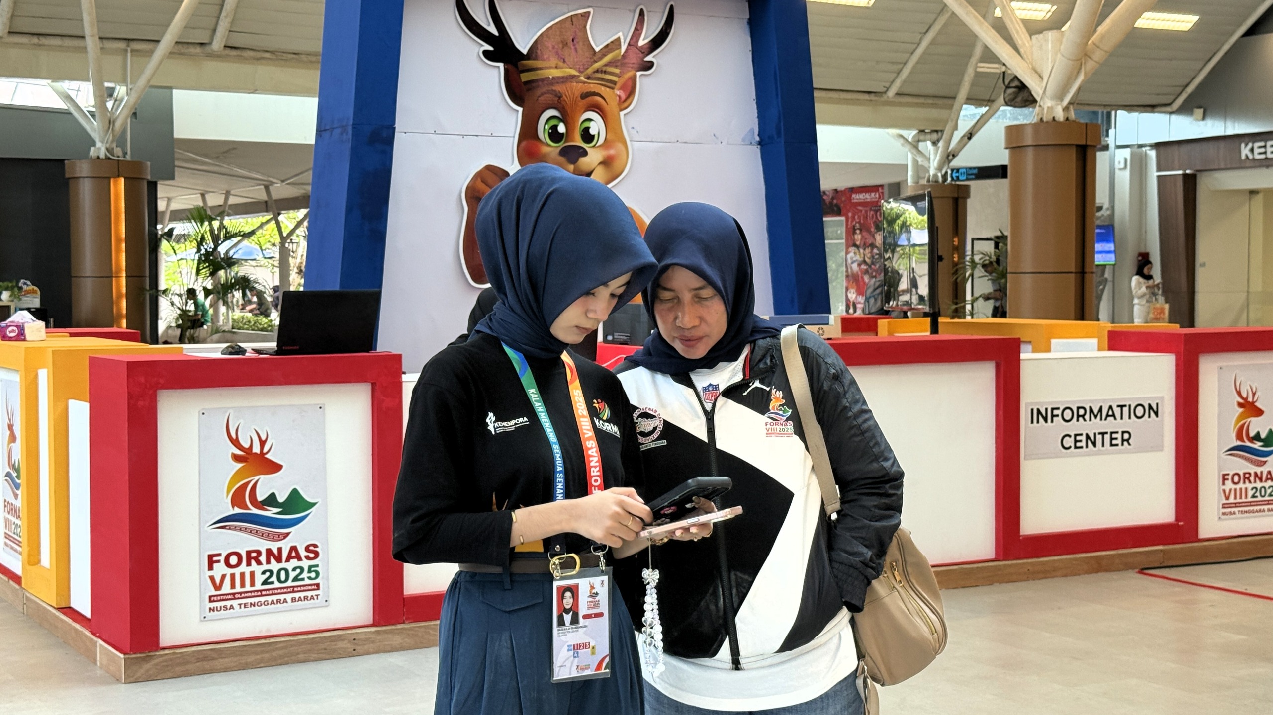 Dua orang penumpang pesawat mengecek handphone saat tiba di BIZAM, Lombok Tengah, beberapa waktu lalu. Bandara Lombok mencatat kenaikan trafik selama event FORNAS VIII NTB 2025.