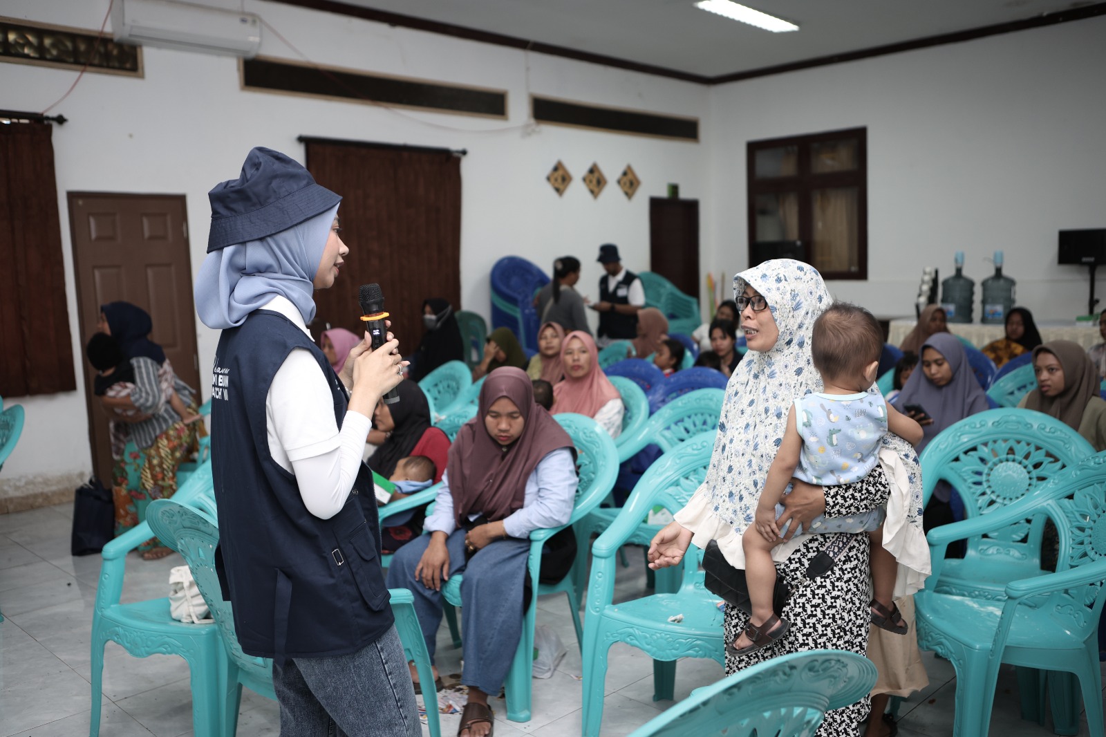 Relawan wanita sedang berdialog dengan seorang ibu usai memeriksakan kondisi sang anak dalam program Relawan Bakti BUMN di kantor Desa Kuta, Pujut, Lombok Tengah, Jumat (15/8).