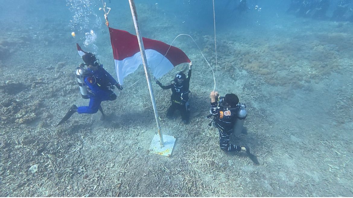 Pengibaran bendera merah putih di perairan Gili Petagan Lombok Timur, Minggu (17/8).