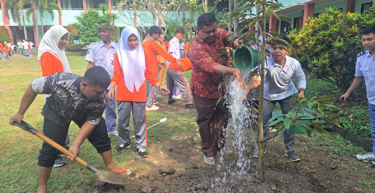 Guru bersama siswa SMKPPN Mataram menanam pohon buah di lingkungan sekolah setempat, Selasa (19/8).