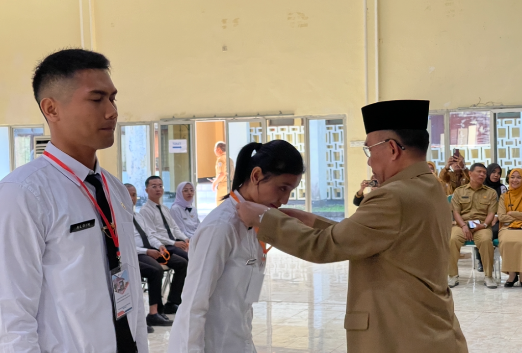 SIMBOLIK: Wakil Wali Kota Mataram TGH Mujiburrahman menyematkan tanda peserta kepada CPNS saat pembukaan Pelatihan Dasar CPNS Angkatan I&ndash;III tahun 2025 di Aula BPSDMD NTB, Selasa (19/8).