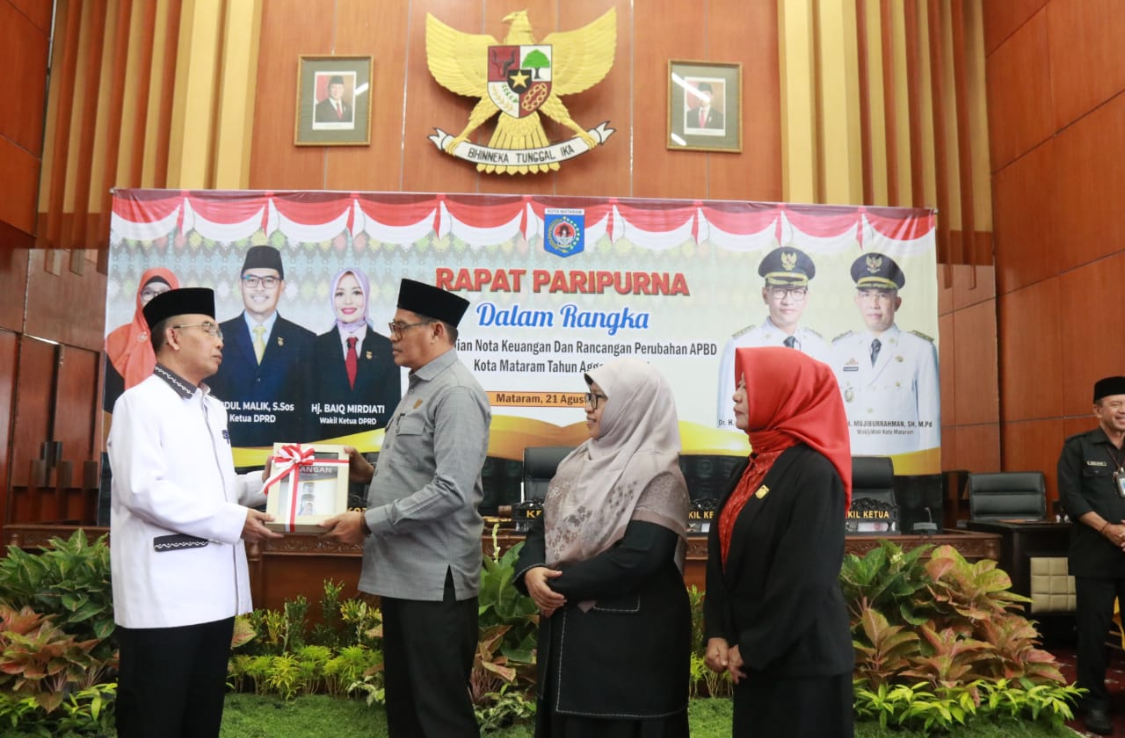 SIMBOLIK: Wakil Wali Kota Mataram TGH Mujiburrahman menyerahkan dokumen Nota Keuangan Rancangan Perubahan APBD Tahun Anggaran 2025 kepada Ketua DPRD Kota Mataram Abdul Malik dalam rapat paripurna.