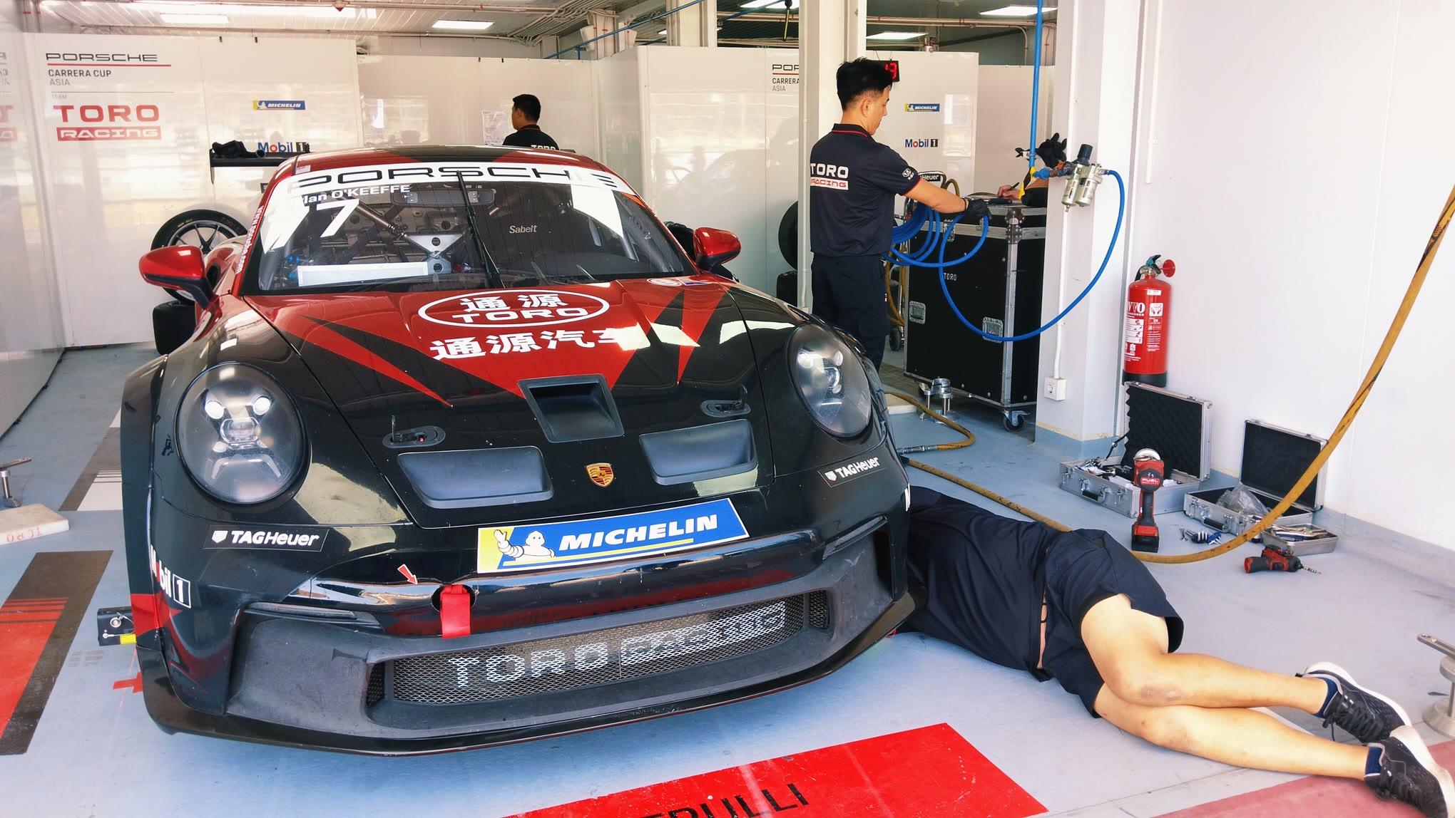 KALI PERTAMA: Tim mekanik mempersiapkan mobil balap sport Porsche 911 GT3 Cup di area paddock Sirkuit Internasional Mandalika, Lombok Tengah, Sabtu (23/8).
