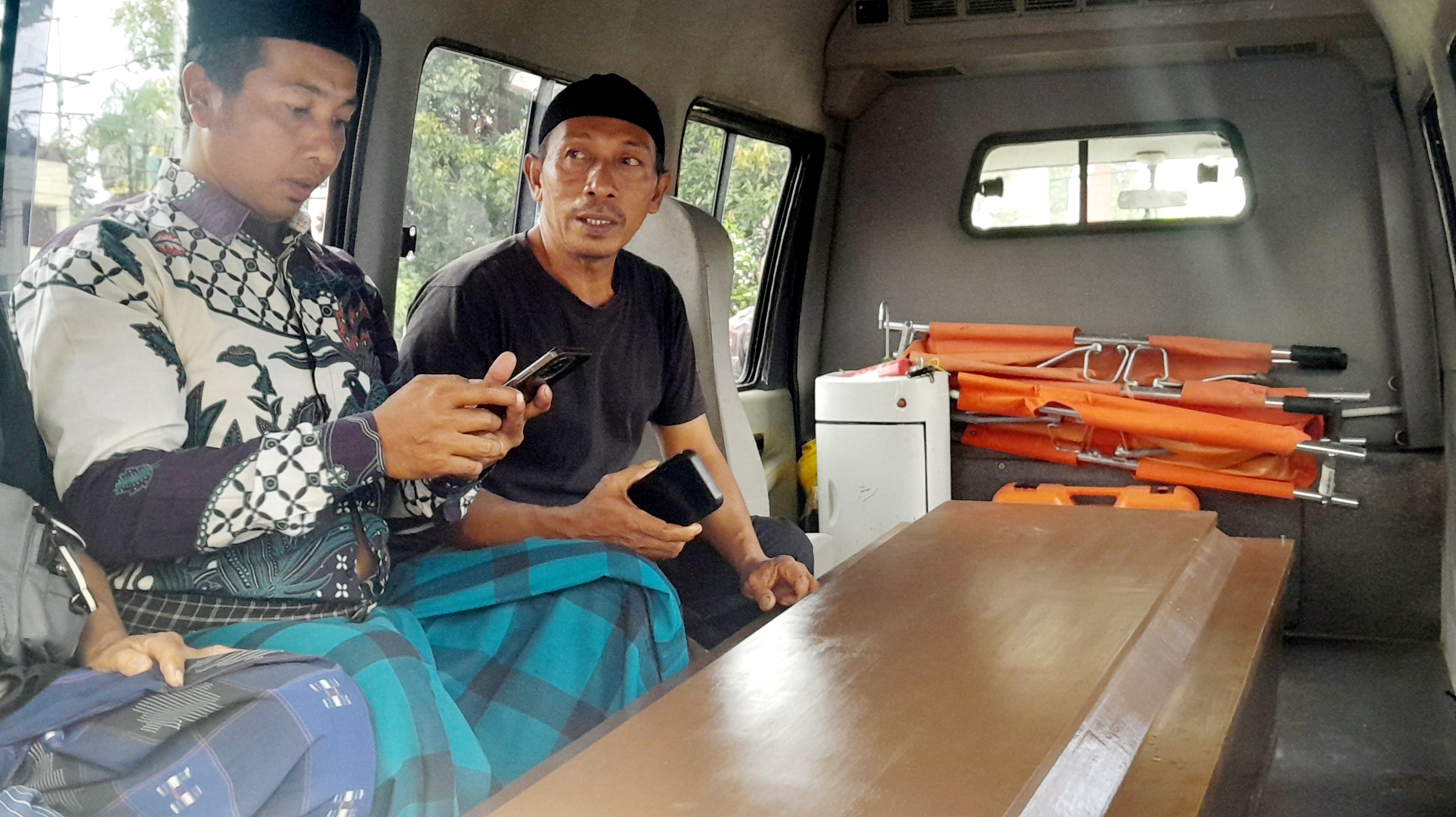 BERDUKA: Ayah Brigadir Esco (paling kanan) Samsul Herawadi saat berada di mobil jenazah usai pelaksanaan otopsi di RS Bhayangkara Mataram, Senin (25/8).