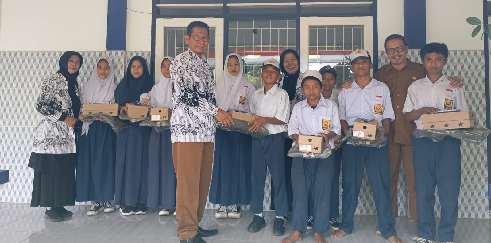 Wakil Ketua PGRI NTB H Chamim Tohari menyalurkan bantuan kepada siswa SMPN 22 Mataram terdampak banjir di sekolah setempat, Selasa (26/8).