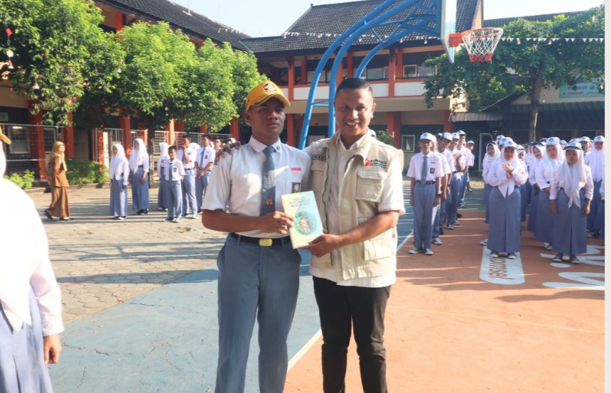 Anggota Bawaslu NTB Hasan Basri bersama seorang siswa, usai upacara bendera.