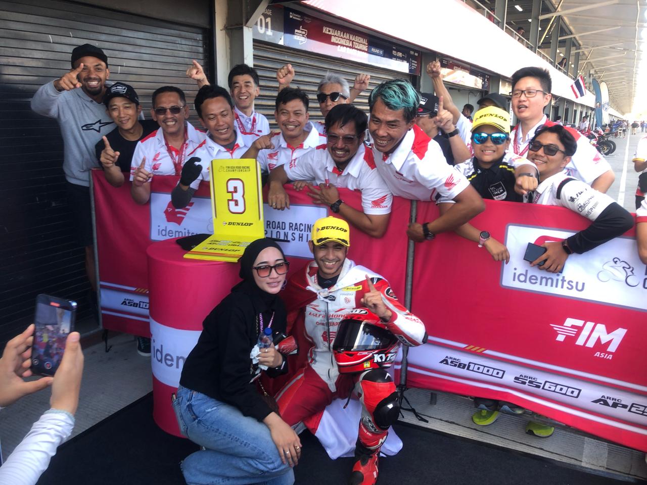 PODIUM ISTIMEWA: Andi Gilang foto bersama istri dan timnya usai merayakan finis di urutan ketiga ajang Asia Superbike 1000 di Sirkuit Mandalika, Minggu (31/8).