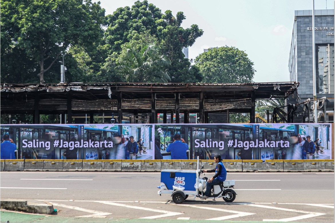 Seorang penjual minuman keliling melewati salah satu ruas jalan di Jakarta.