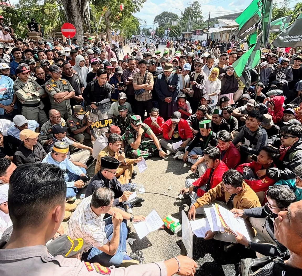 Bupati Dompu Bambang Firdaus dan 26 anggota DPRD Dompu duduk di tengah-tengah massa aksi di depan kantor DPRD setempat, Senin (1/9).
