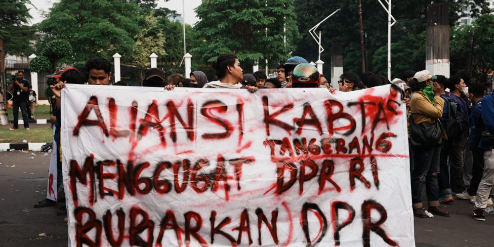 Spanduk membentang berisikan protes kepada DPR.