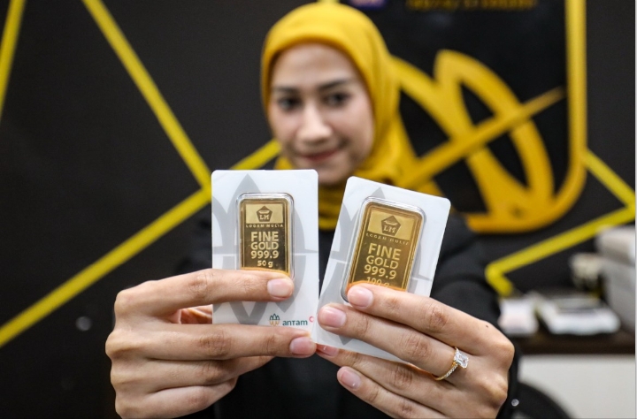 NAIK HARGA: Petugas menunjukkan emas Antam di Butik Emas Logam Mulia PT. Aneka Tambang (Antam) di kantor pusat Jalan TB. Simatupang, Jakarta. Harga emas Antam (ANTM) naik menjadi Rp 2 jutaan.