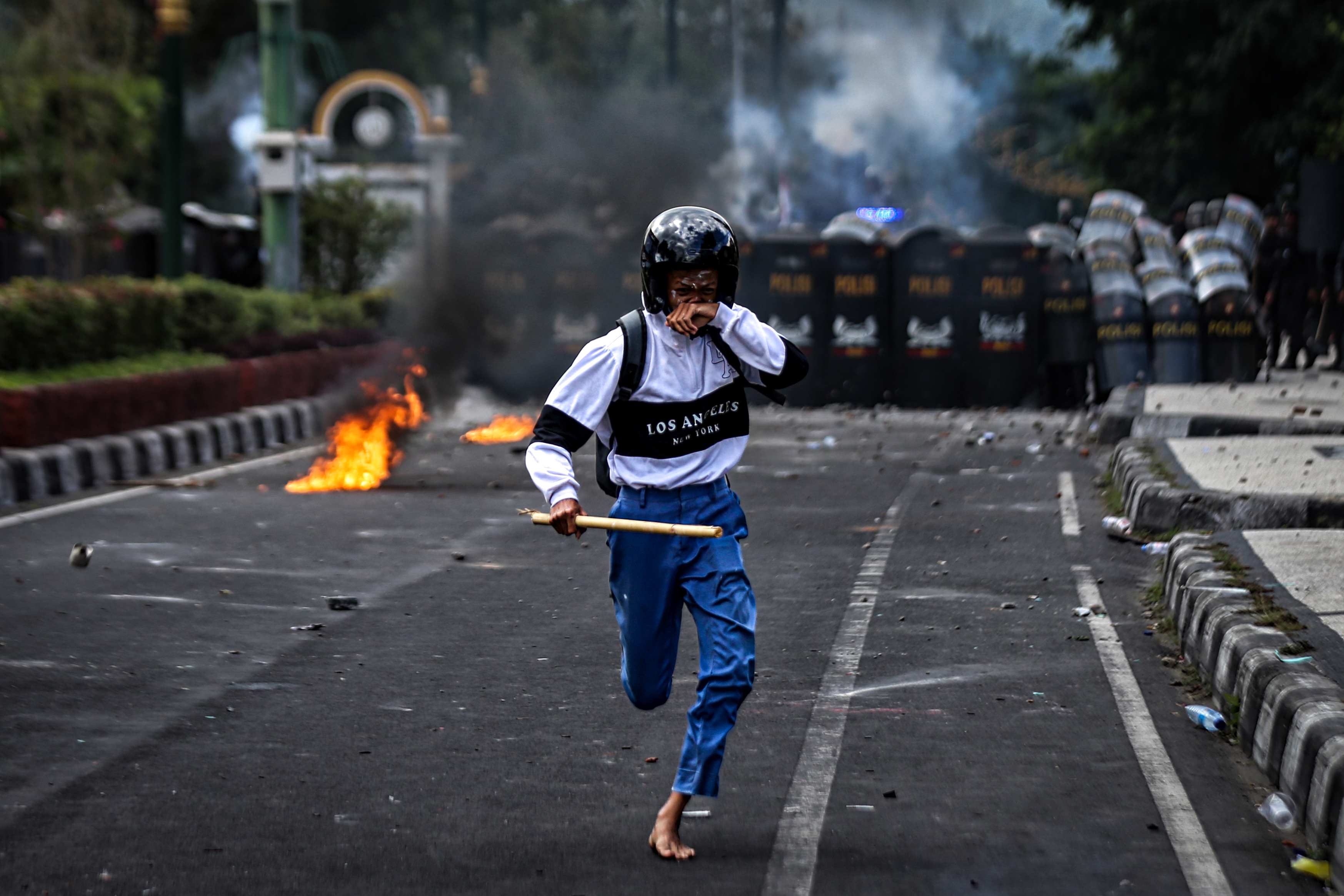 SEMPAT MENCEKAM: Seorang pengunjuk rasa menjauh dari barisan pengamanan kepolisian di Jalan Udayana, saat aksi demonstrasi akhir pekan lalu.