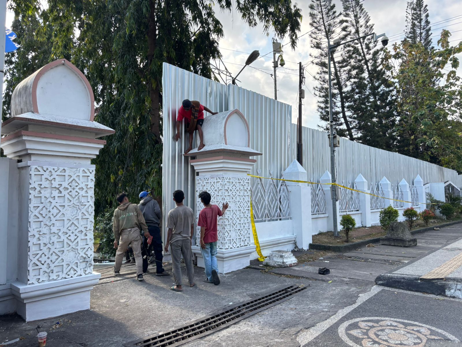 UNTUK KESELAMATAN: Para petugas memasang seng penutup, di depan gedung DPRD NTB sudah hangus terbakar, Kamis (4/9).