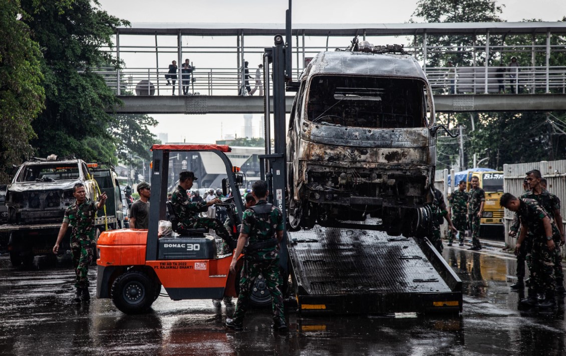 DIBAKAR MASSA: Anggota TNI mengevakuasi kendaraan polisi yang terbakar ke dalam trailer dengan forklift di Mapolresta Jakarta Timur, Jakarta, Sabtu (30/8) lalu.