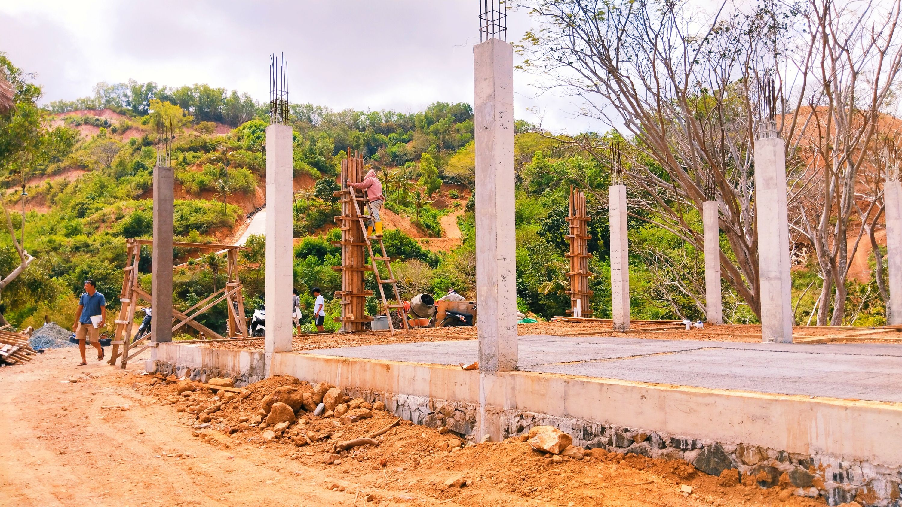 LAYANGKAN SP1: Sejumlah buruh sedang membangun pondasi dan pilar sebuah bangunan yang berada di atas perbukitan Desa Kuta, Pujut, Loteng, beberapa waktu lalu.