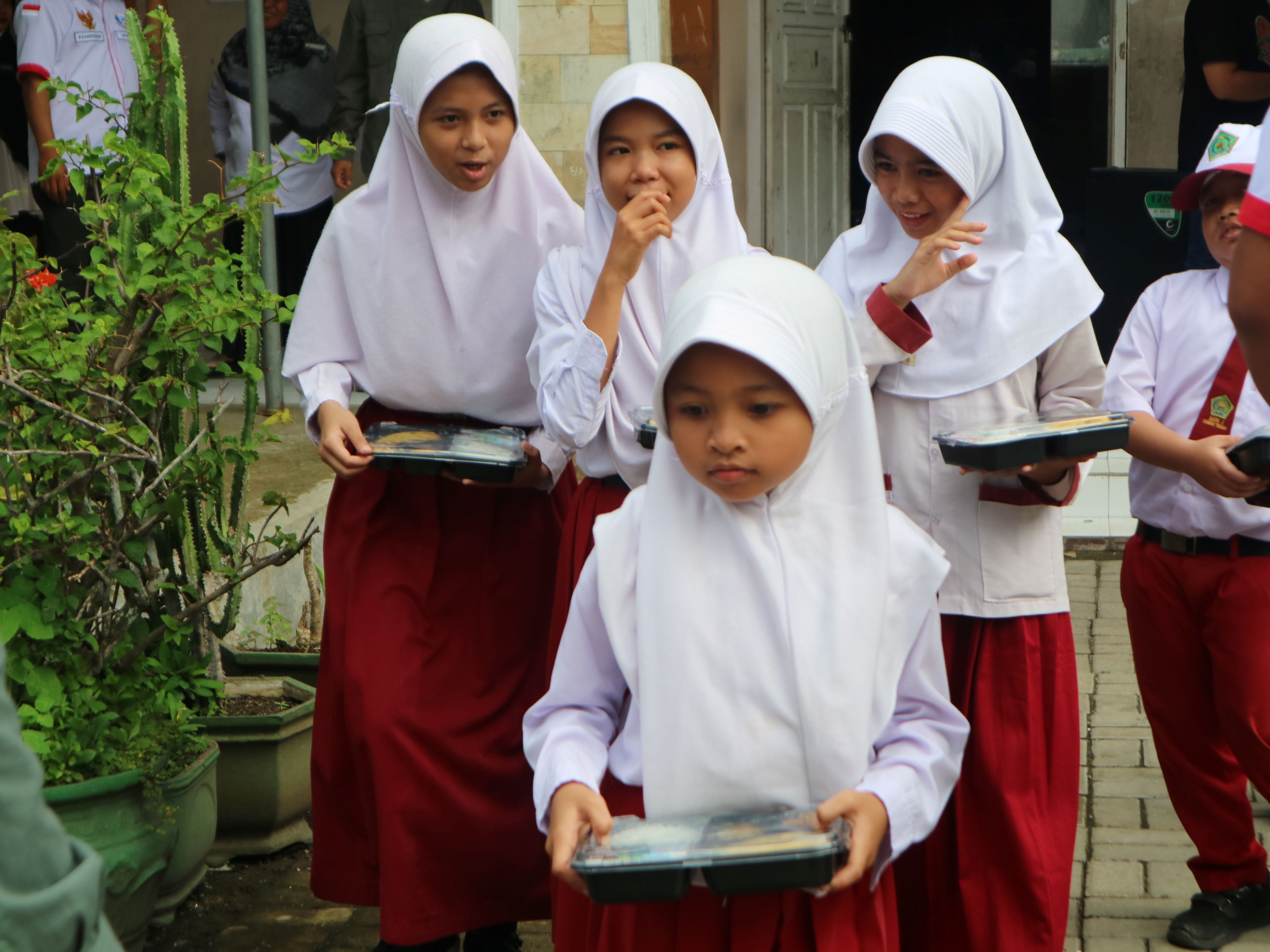 EVALUASI: Para murid membawa paket MBG yang dibagikan di sekolah, Loteng, beberapa waktu lalu. Pemkab Loteng segera evaluasi pelaksanaan program MBG di daerah.