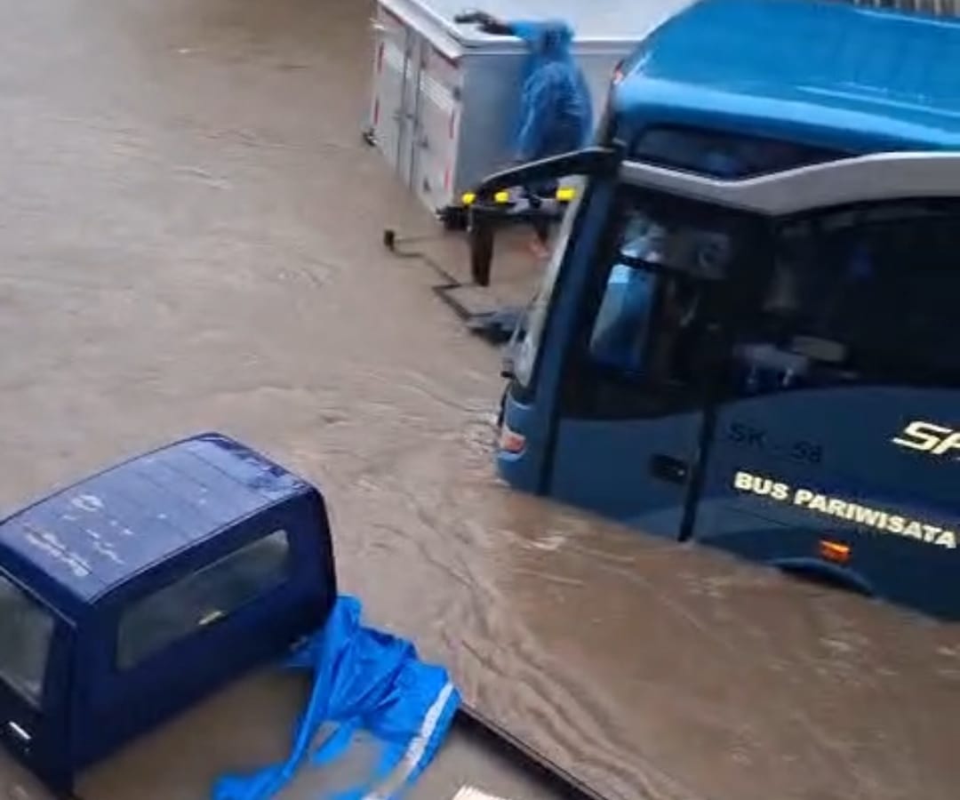 Salah satu ruas jalan Gajah Mada yang ada di Denpasar merendam bangunan dan banyak kendaraan termasuk bis pariwisata.