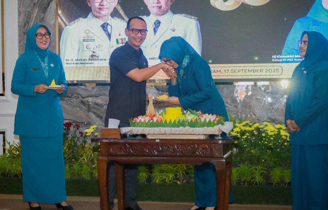 Ketua TP PKK Kota Mataram Kinnastri Mohan Roliskana memberikan potongan tumpeng kepada Wali Kota Mataram Mohan Roliskana saat puncak HKG PKK ke-53 di Pendopo Wali Kota, Rabu (17/9).