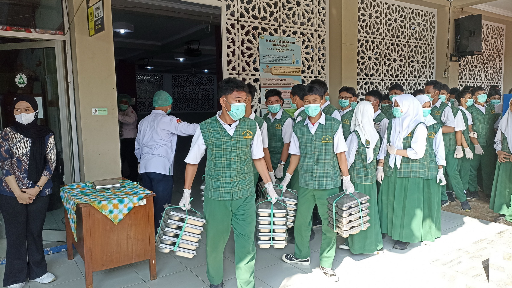 Murid di MTSN 6 Jakarta membagikan MBG untuk teman-temannya, Selasa (26/8). Pembagian MBG dipantau langsung Menteri Agama Nasaruddin Umar.&nbsp;