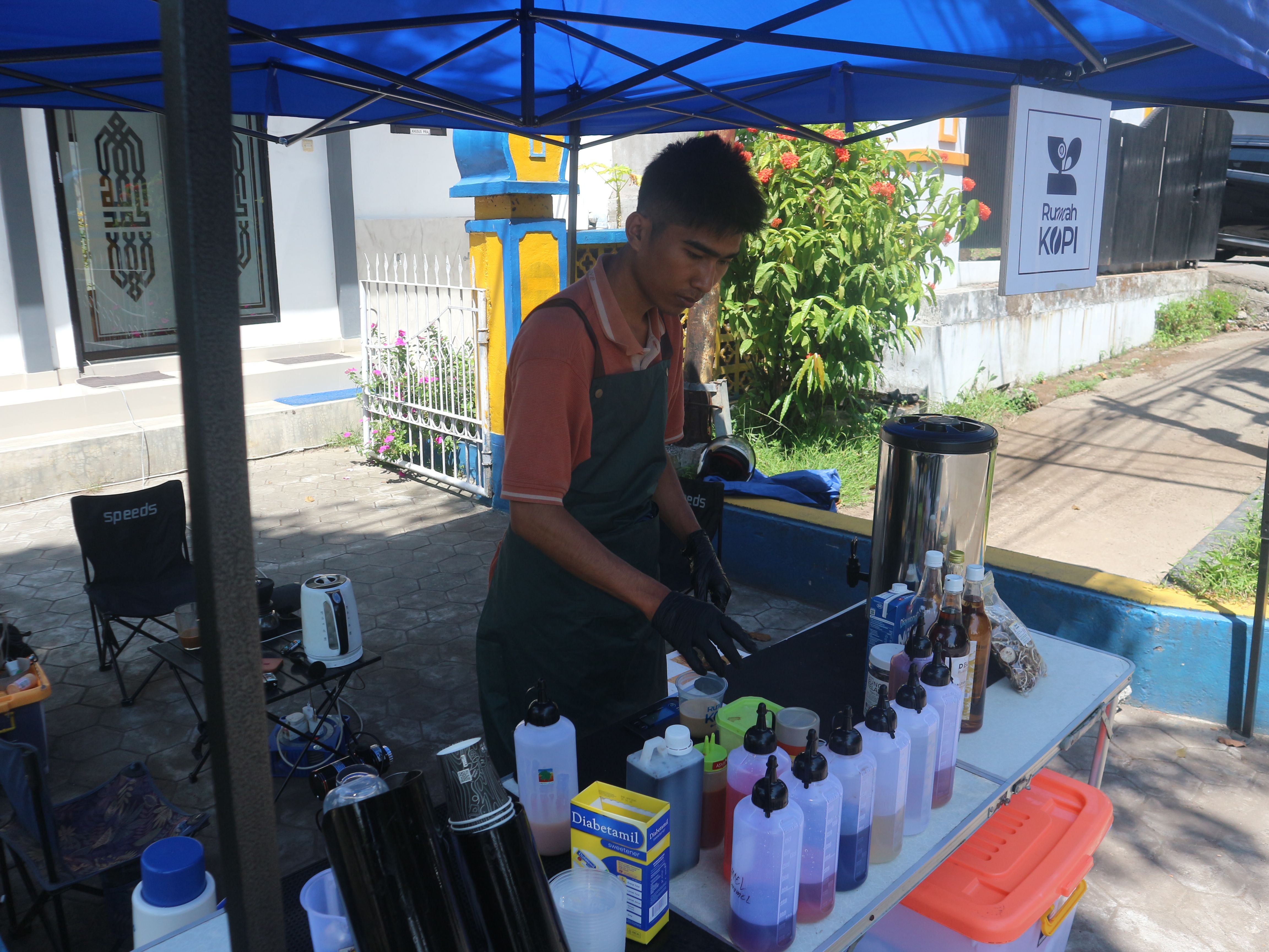 Muhammad Asrio Romdi penjual kopi keliling saat membuatkan pesan salah seorang pembeli, saat jualan di samping gerbang keluar Kantor Bupati Lombok Timur, Selasa (16/9)
