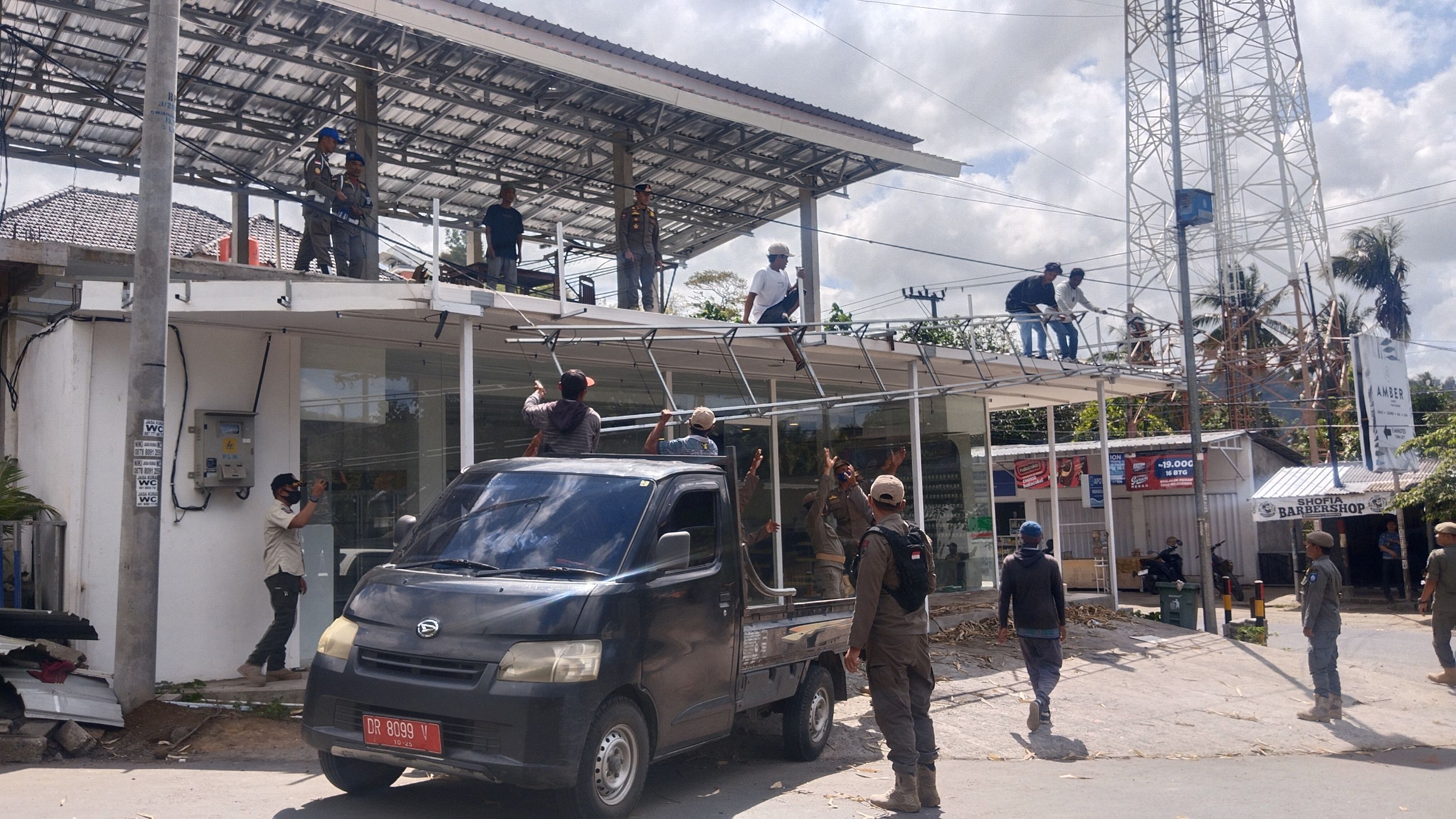 Puluhan petugas Satpol PP Loteng membongkar sebagian bangunan minimarket yang melanggar aturan pembangunan di Desa Selong Belanak, Praya Barat, Loteng, Rabu (17/9).